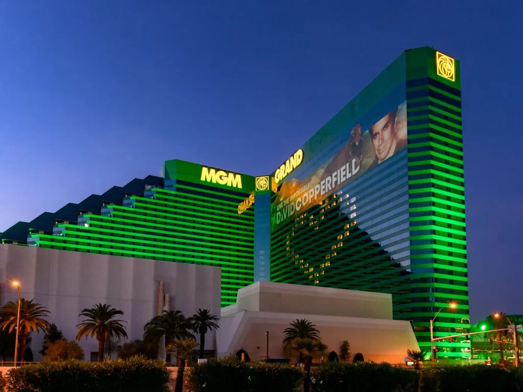 Interior de una lujosa habitación de hotel en Las Vegas, con una mano usando una aplicación de apuestas deportivas en un teléfono y un boleto de apuesta falsificado en la pantalla.