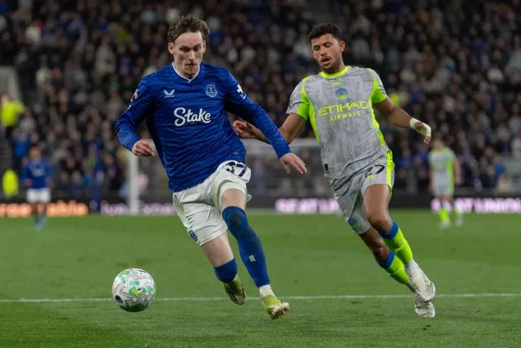 Partido de la Premier League 2026/27 en un estadio inglés con aficionados y marcador electrónico